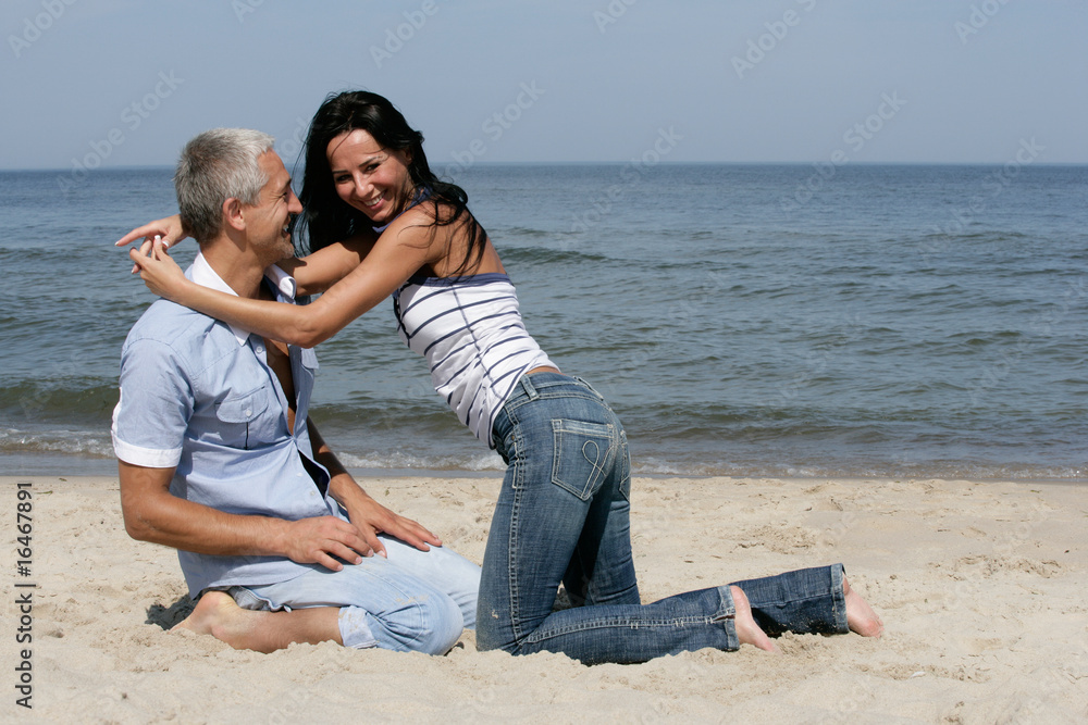 Happy middle aged couple having fun on the beach