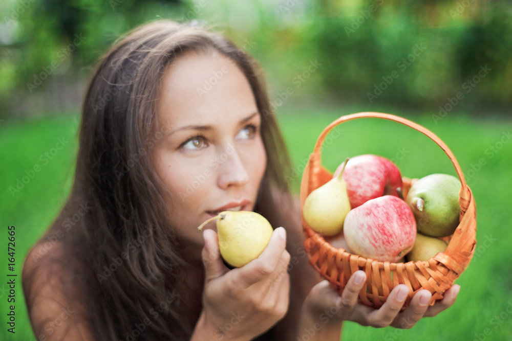 Beautiful woman outdoor with apples and pears in the crib Beautiful woman outdoor with apples and pears in the crib