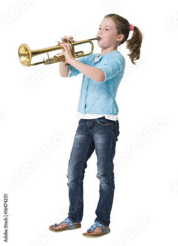 Pretty young girl blowing trumpet on white background