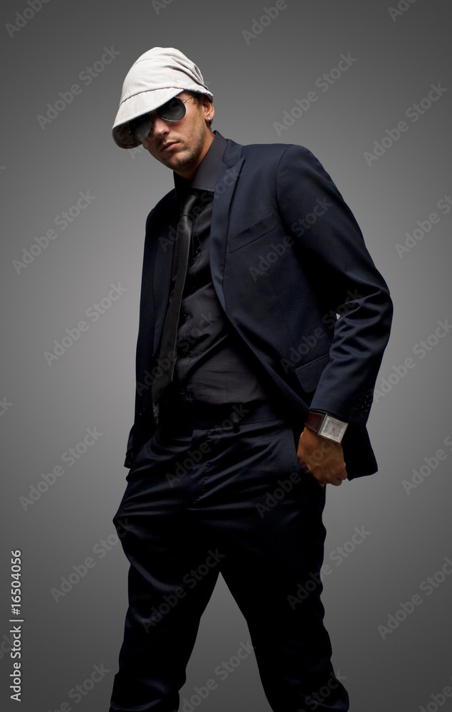 studio shot of a young man wearing black suit and sunglasses studio shot of a young man wearing black suit and sunglasses