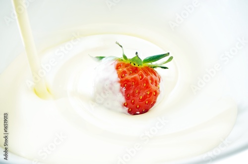 cream being pored over strawberry