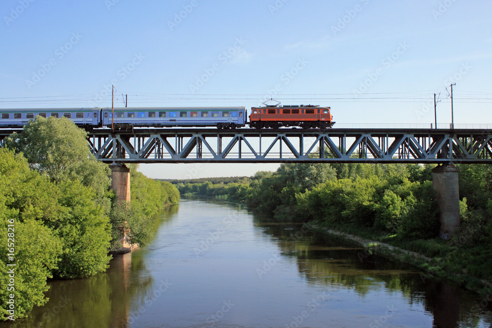 Fototapeta premium Pociąg Intercity przechodzący przez stalowy most nad rzeką
