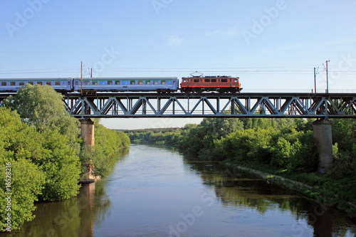 Intercity train passing the steel bridge over the river