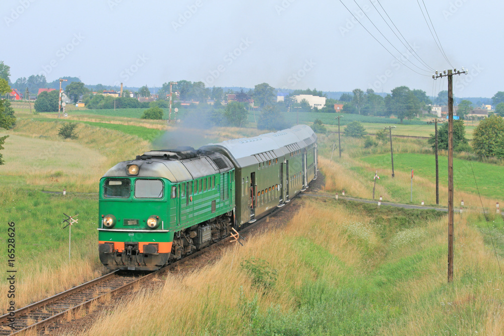 Passenger train passing through polish countryside