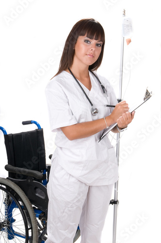 medical doctor with stethoscope writing and handicaped chair photo