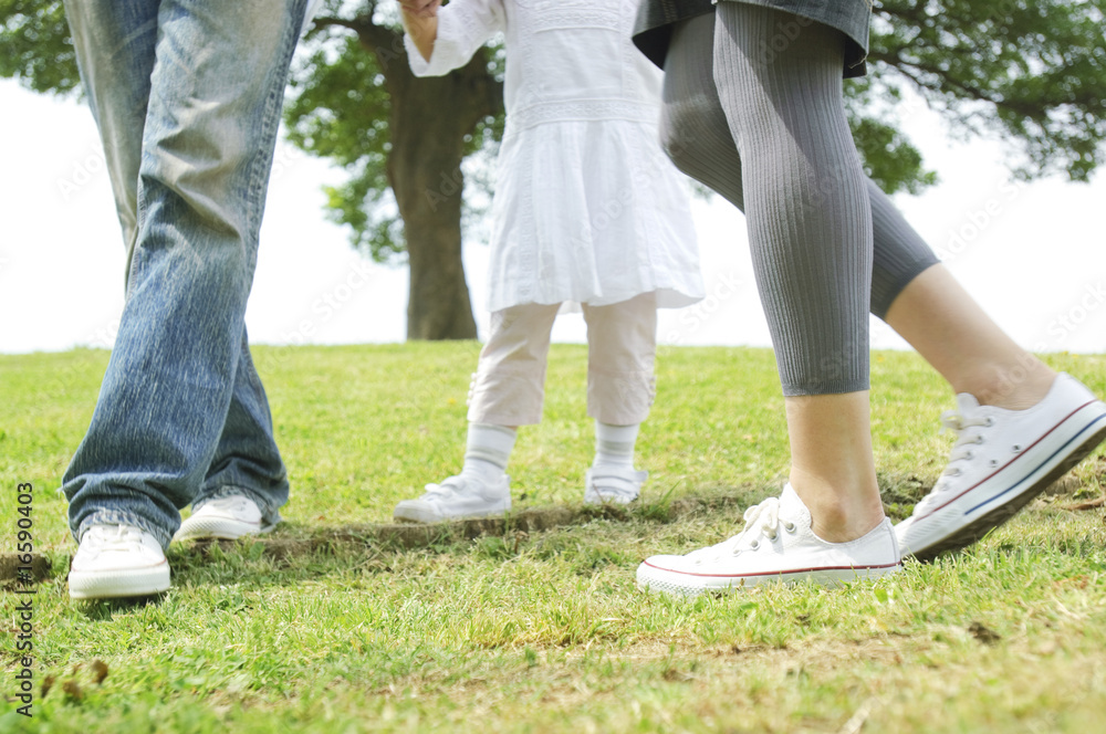 公園を歩く女の子と両親の足元