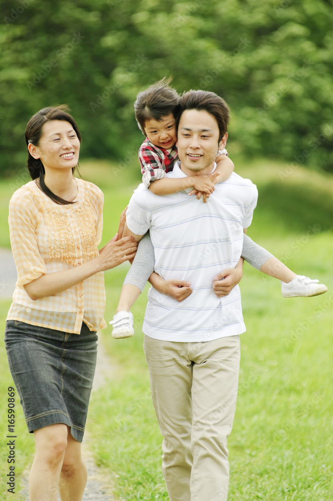 娘をおんぶする父親とそばを歩く母親 Stock Photo Adobe Stock 娘をおんぶする父親とそばを歩く母親 Stock Photo Adobe Stock