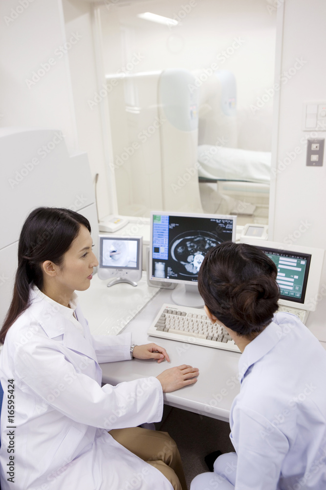 Obraz premium ctの画像を見ながら話す女医と技師
