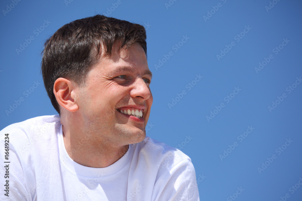 Fototapeta premium smiling guy against blue sky