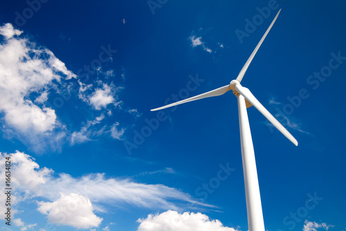 wind turbine and airplane on blue sky