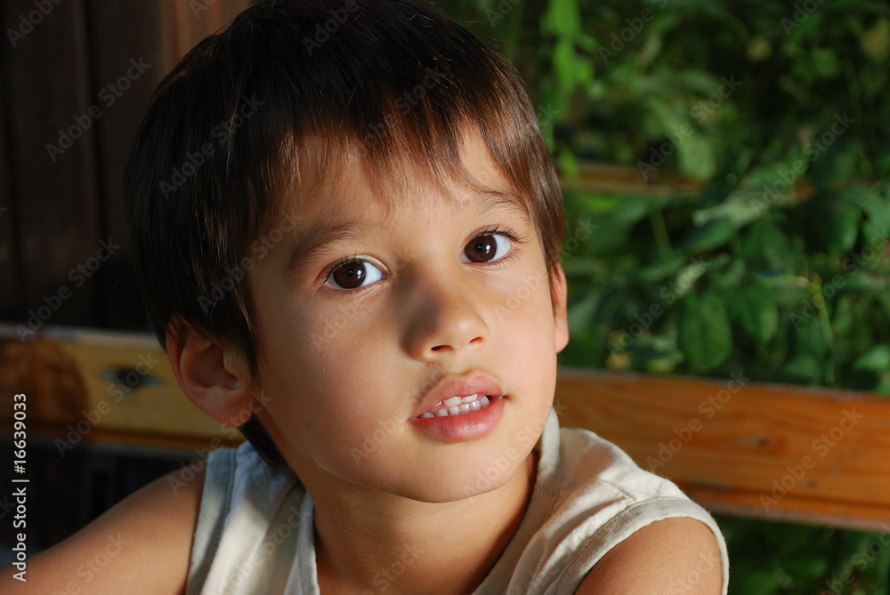 Cute male child is sitting outdoor, closeup Cute male child is sitting outdoor, closeup