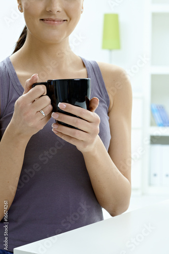 Female hands holding tea cup