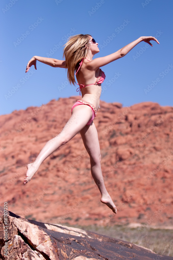 Woman in bikini jumping outdoors