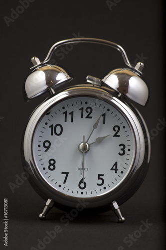 Nice old vintage chrome metal twin bell alarm clock on black background.