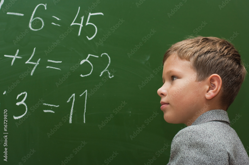 The schoolboy solves examples at a mathematics lesson The schoolboy solves examples at a mathematics lesson