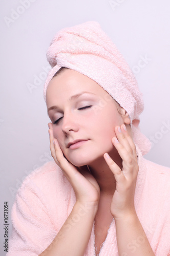 young woman applying creme on face