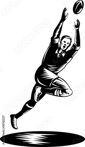 Rugby player jumping to catch ball
