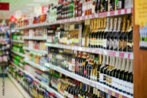 Shelf with beer bottles in a supermarket, blur