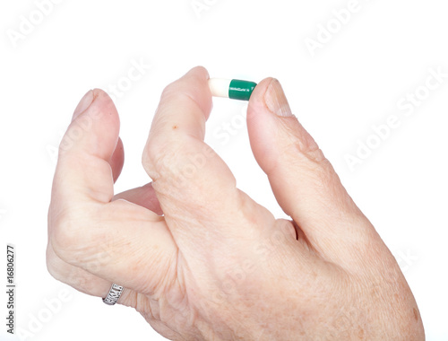 hand of the old woman holds capsule with medicines