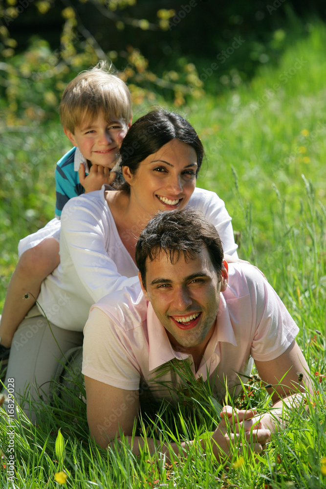 Fototapeta premium homme et femme avec un petit garçon couchés dans l'herbe