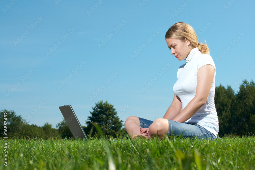 The girl with laptop on a green lawn The girl with laptop on a green lawn