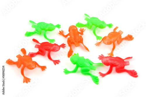 colorful plastic frog toys over white background