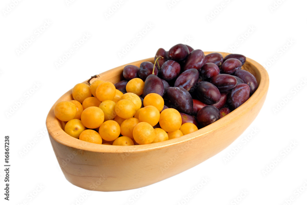 Fototapeta premium Two kinds of plums in a wooden bowl