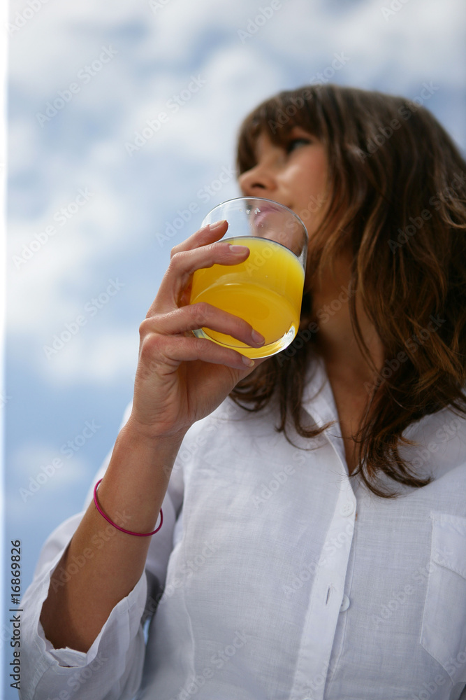 Femme avec un verre de jus d'orange à la main Femme avec un verre de jus d'orange à la main