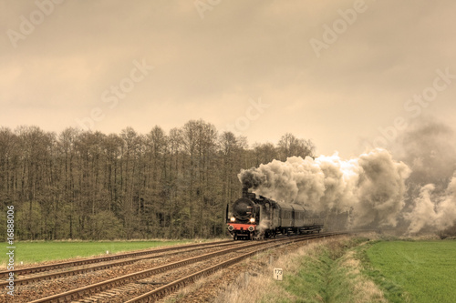 Old retro steam train passing through countryside