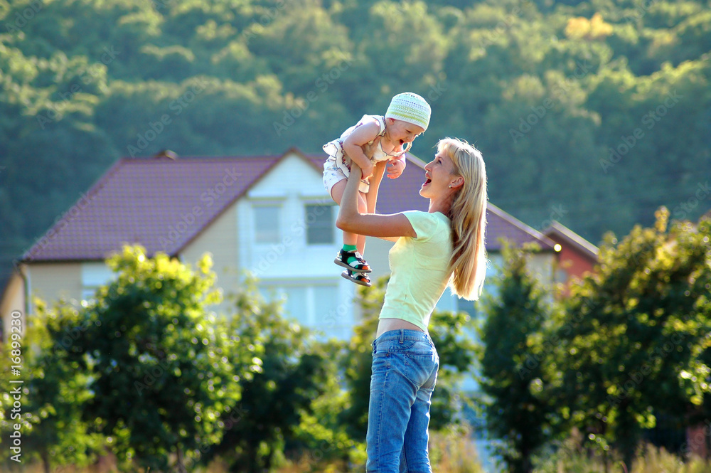 Obraz premium Happy mother keeps small girl on hand