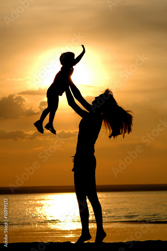 Silhouettes of the women and child on sundown