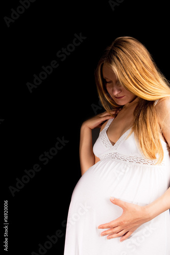 attractive young pregnant blonde in white nightshirt isolated