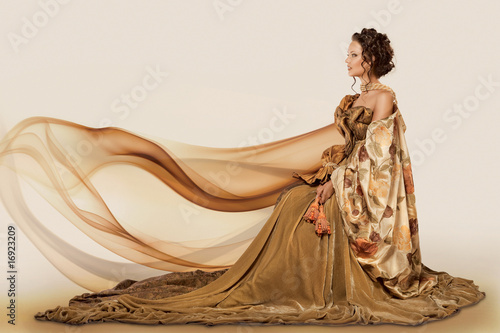 Foto Woman sitting in a formal full flowing gown