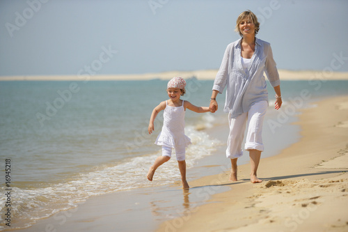 Femme se promenant au bord de la mer avec une petite fille