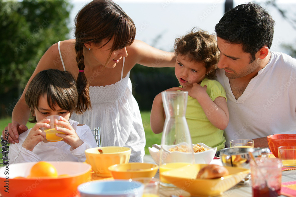 Couple prenant leur petit déjeuner avec deux enfants Couple prenant leur petit déjeuner avec deux enfants