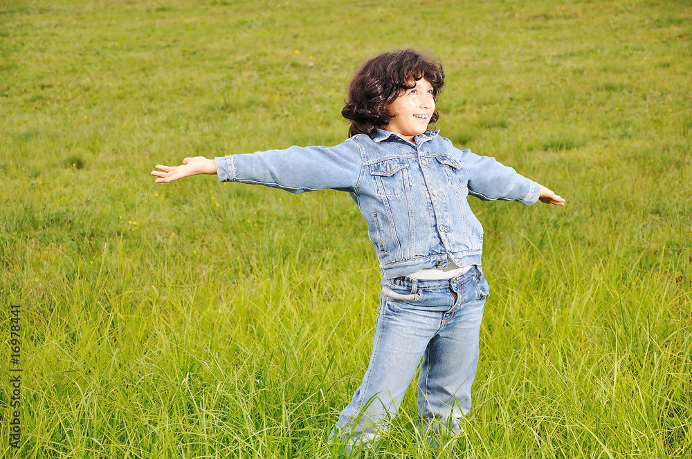 A little cute happy girl standing on green ground
