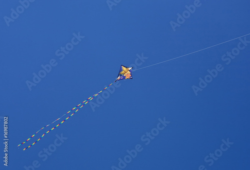 A colourful kite against a vivid blue sky