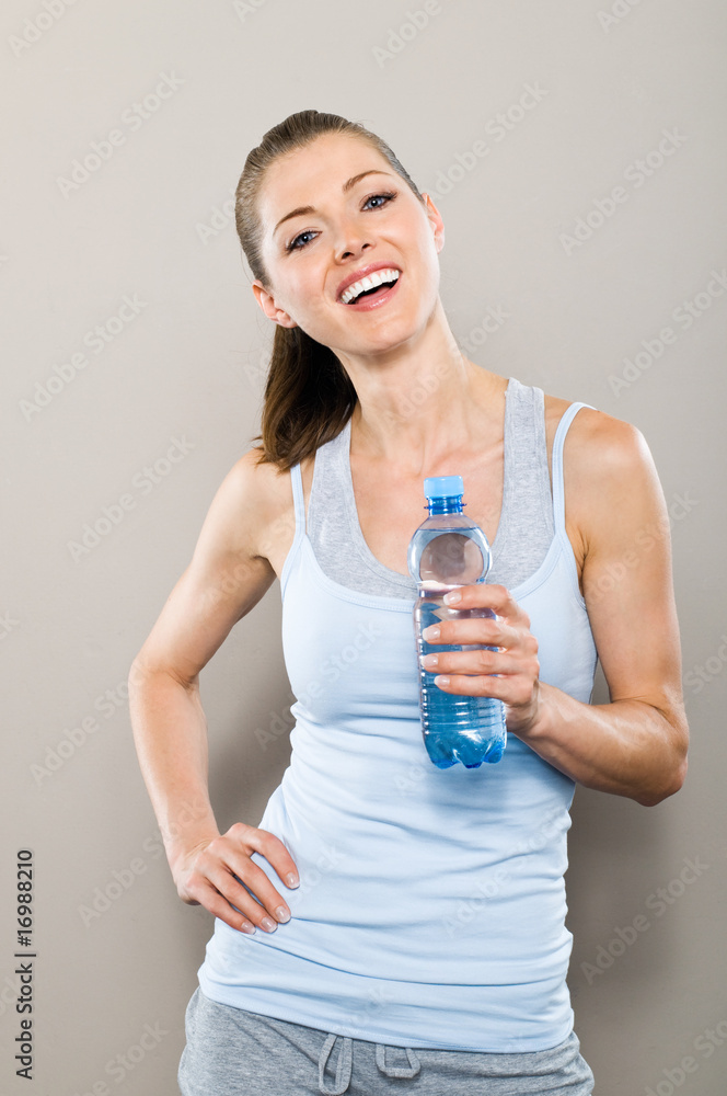 Sportlich lachende Frau hält Wasserflasche Sportlich lachende Frau hält Wasserflasche