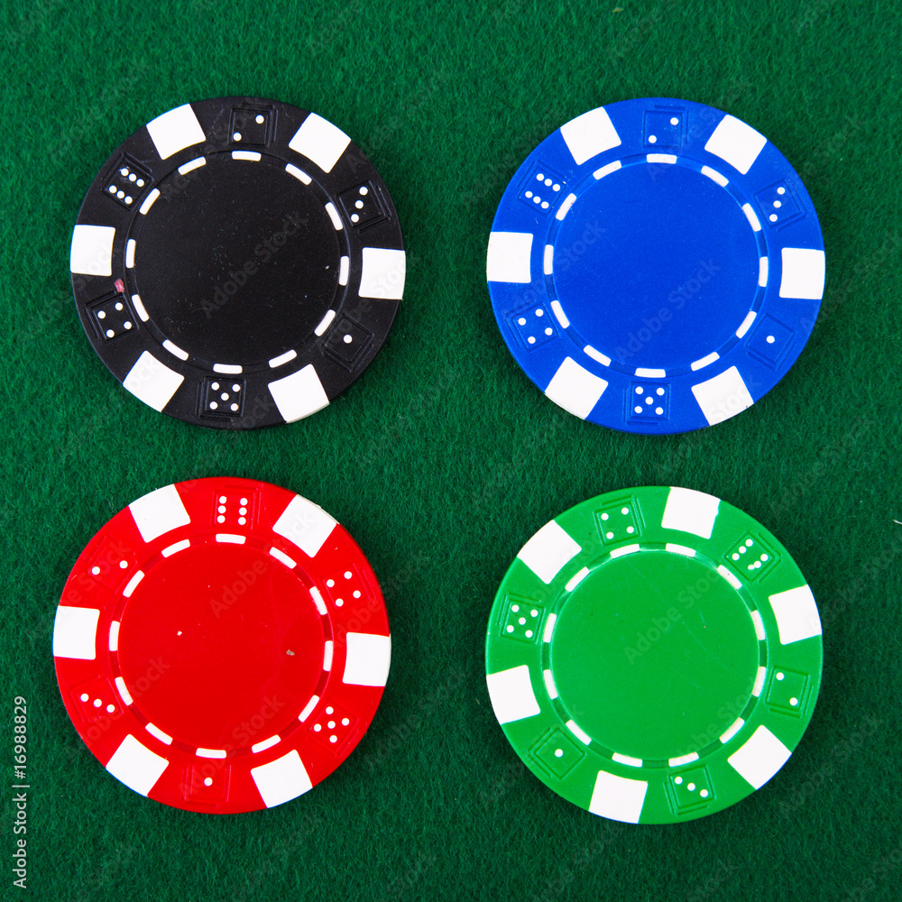 Naklejka premium Casino chips each different color on green felt