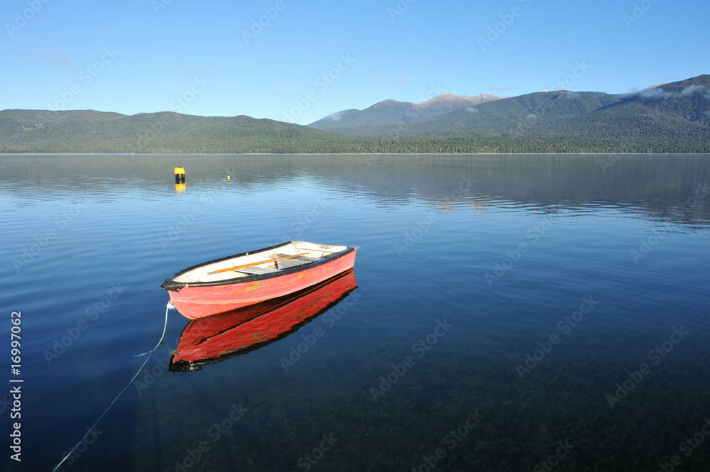 Red boat on the lake Te Anau in south New Zealand