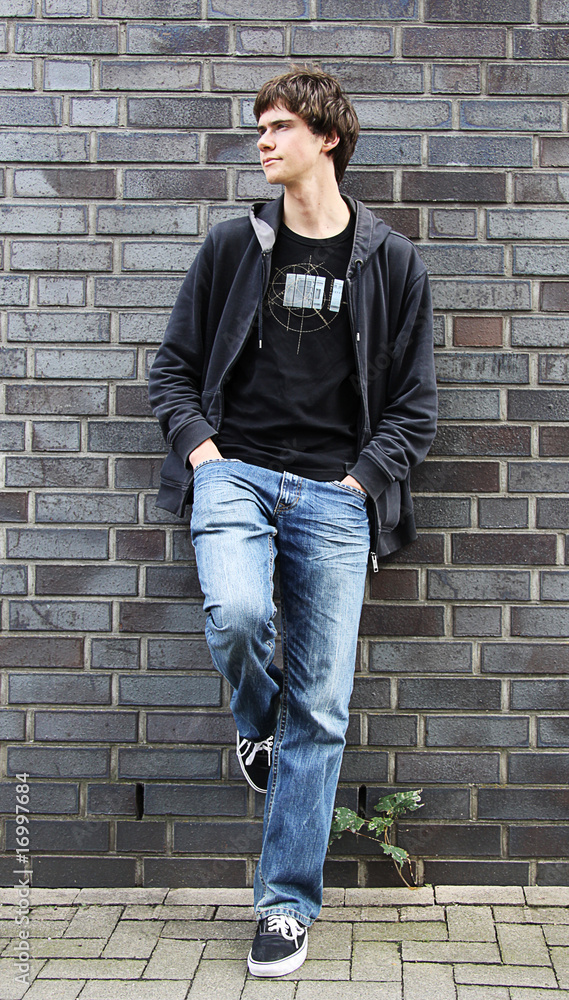 Portrait of the young man standing at a wall Portrait of the young man standing at a wall