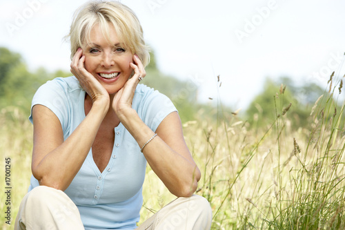 Portrait of mature woman sitting in countryside photo