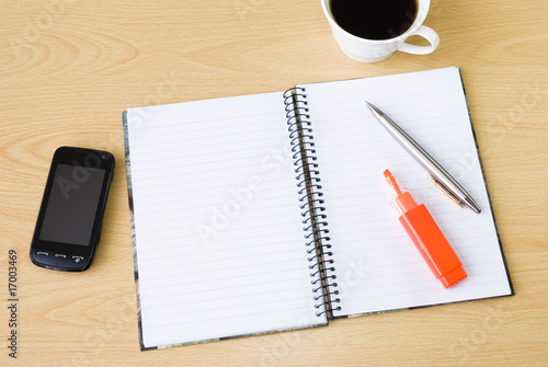 Cell phone  notebook and cup of coffee