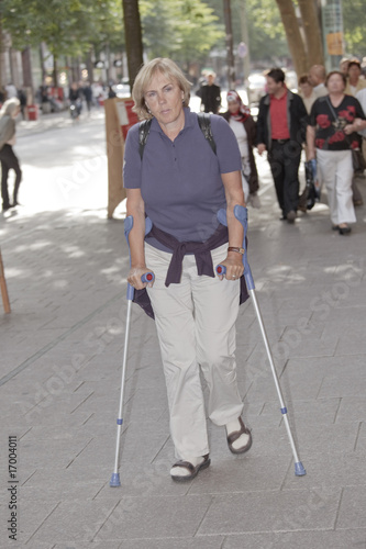 Woman with crutches in the city