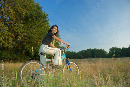 young female riding a bike in nature