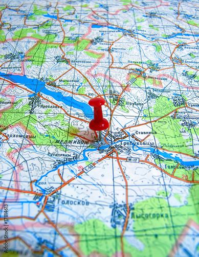 Red pushpin marking a location on a road map.