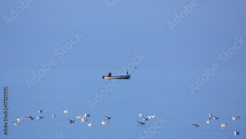 Fischer mit Fischreihern in einem Boot