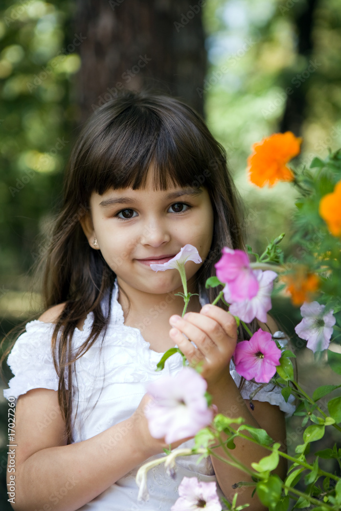 Beautiful curious girl with flower in a summer garden Beautiful curious girl with flower in a summer garden