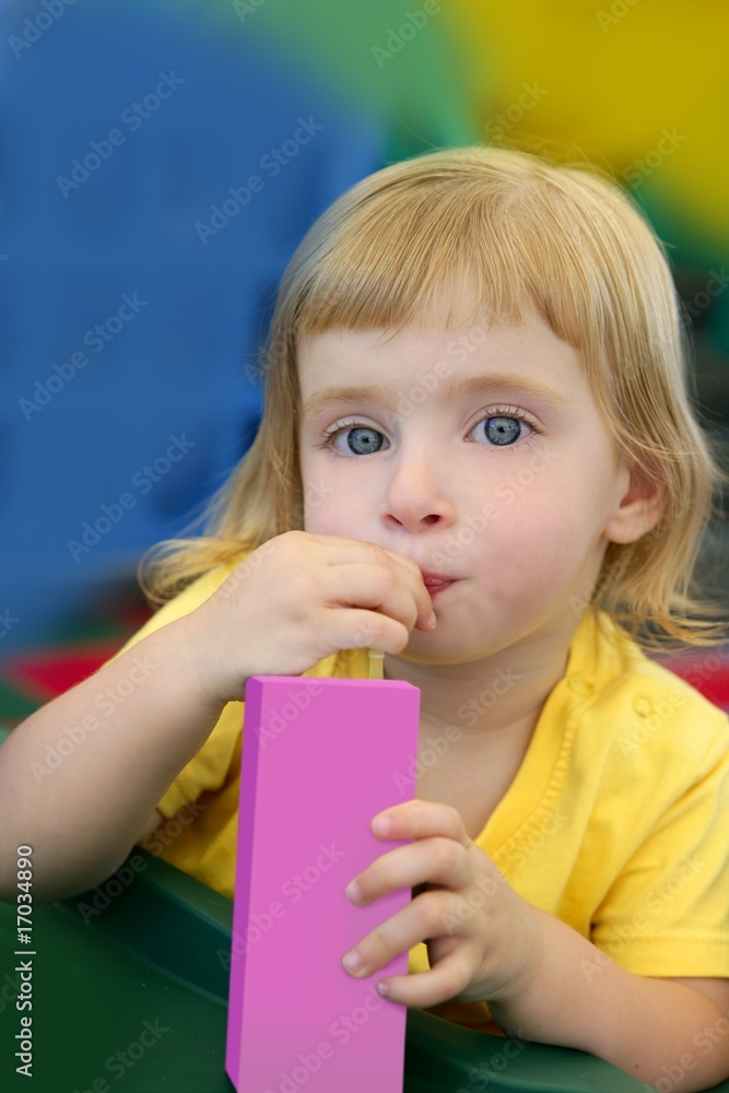 Beautiful blond girl drinking pink juice