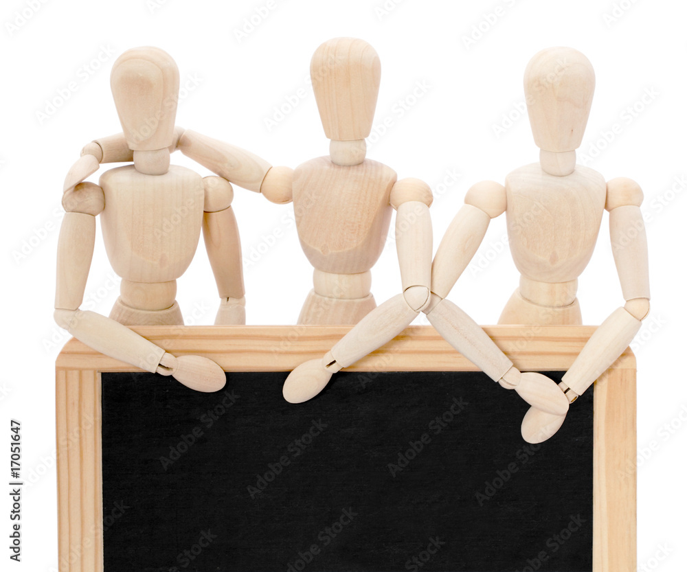 Trois pantins debout derrière un tableau noir